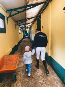 Niña acompañada por monitor por los establos